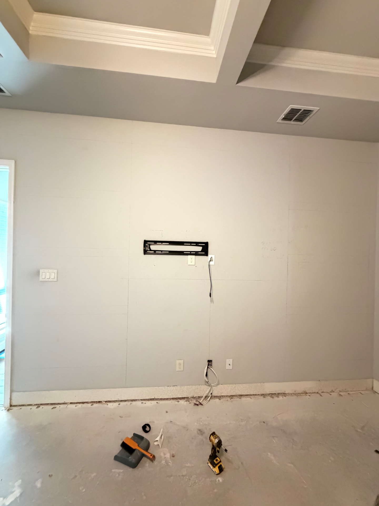 Bare bedroom wall with TV bracket before the built-in media wall